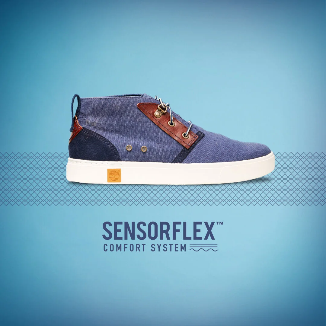 A blue sneaker with brown leather accents and a white sole, presented on a blue background with 'SensorFLEX Comfort System' text.