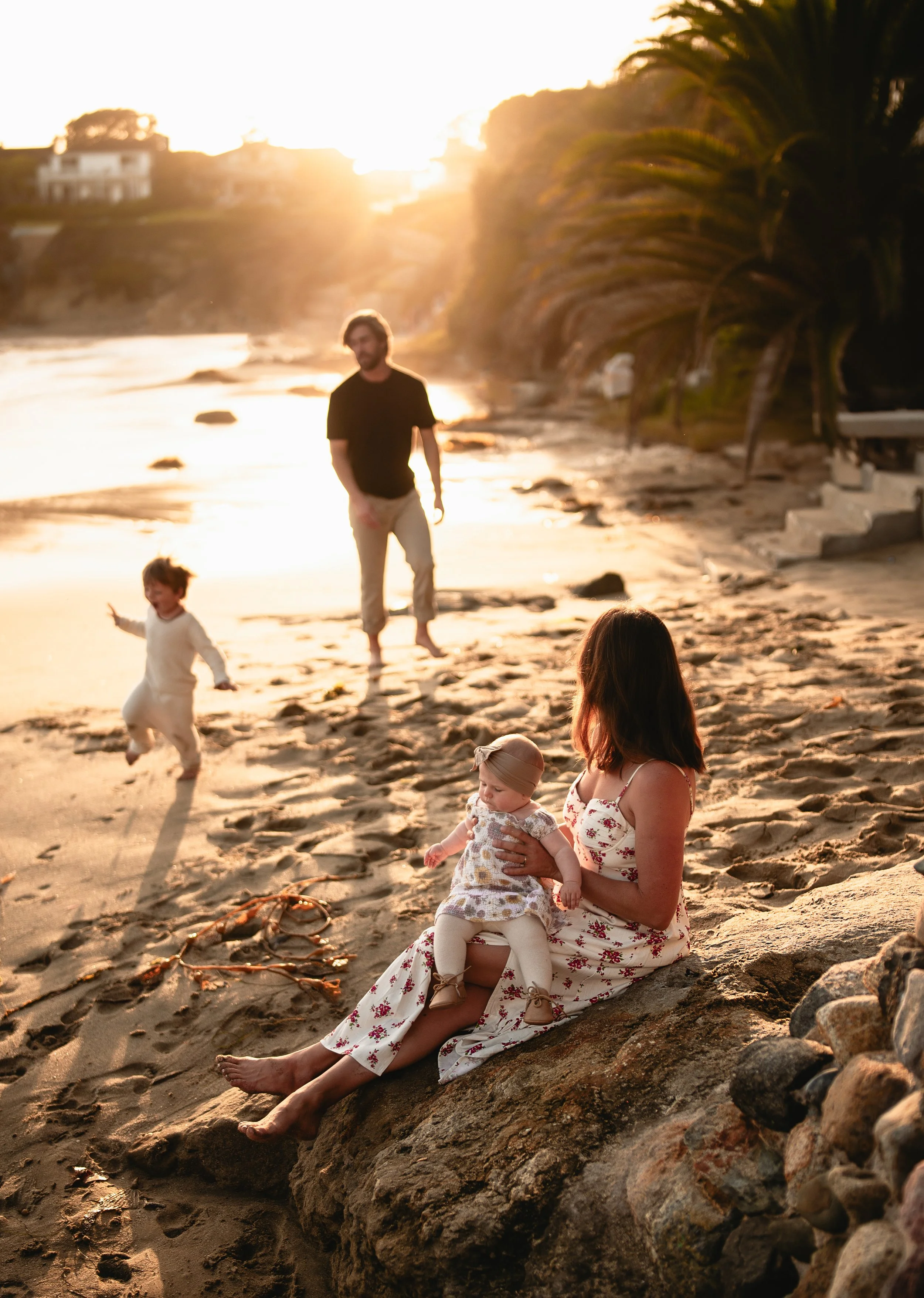 family playing at the beach during sunset