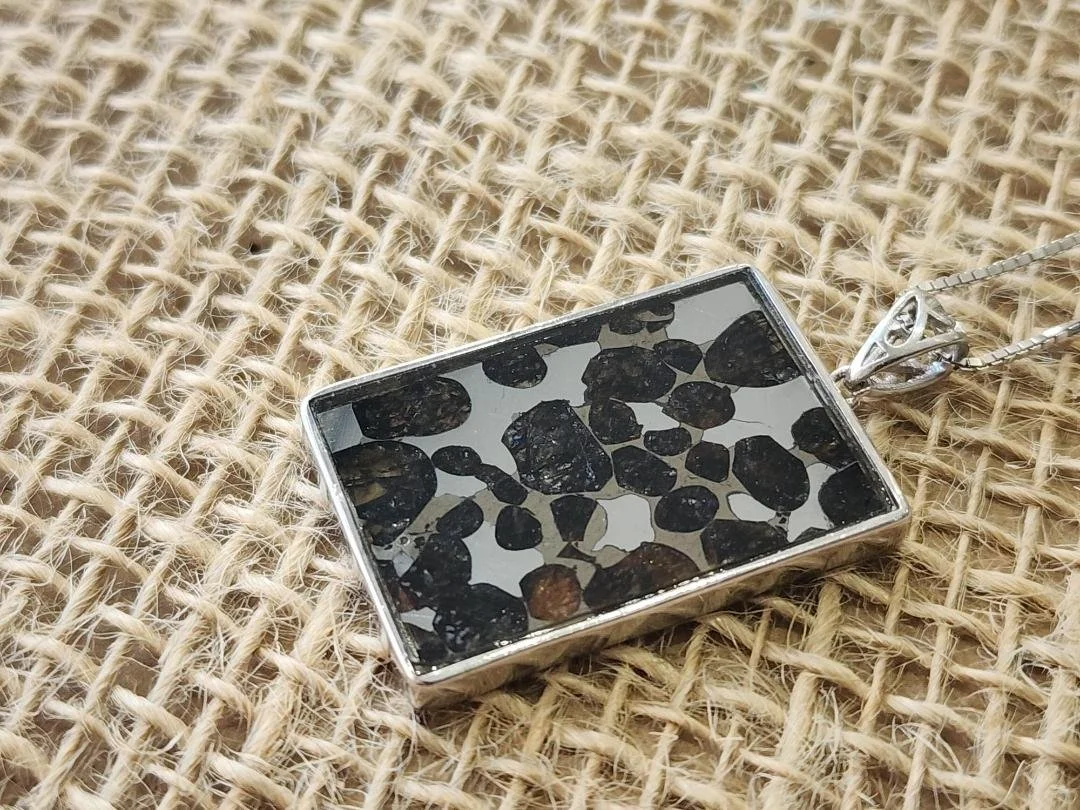 rectangular necklace with Sericho meteorite on a burlap background