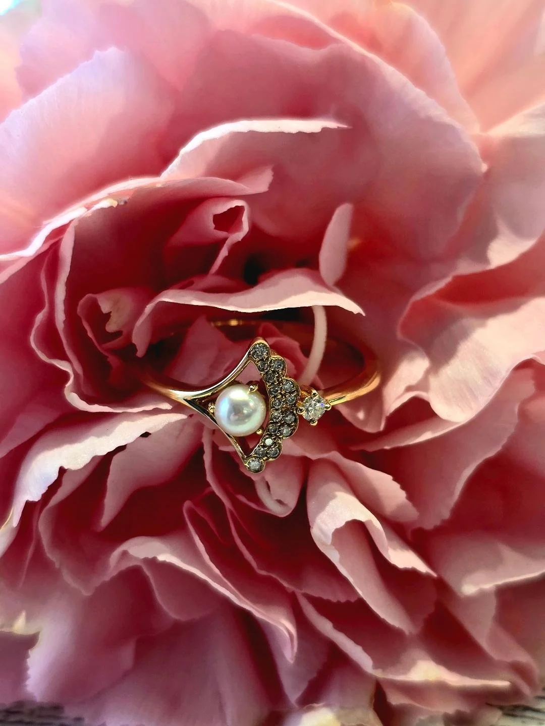 Front view of yellow gold pearl ring in a pink carnation