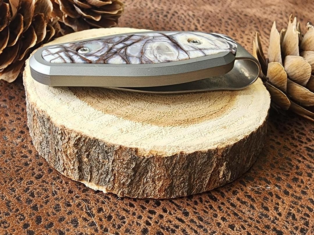 side view Titanium money clip inlayed with mammoth ivory on wood slice