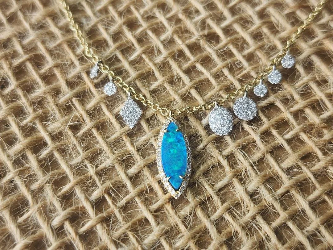 Blue green boulder opal necklace with diamond accents on a burlap background