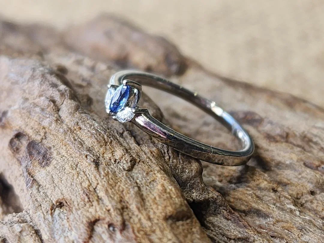 Yogo sapphire and diamond ring on rock with burlap background