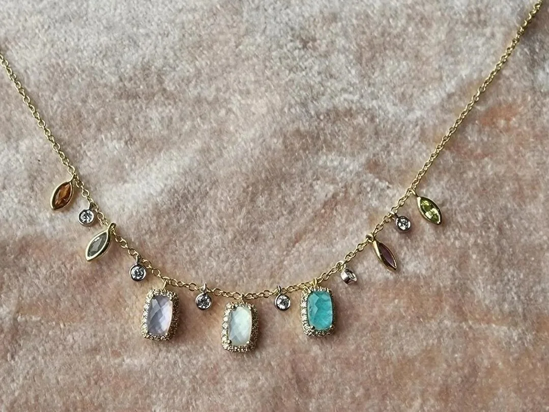 Multi colored pastel necklace in 14k yellow gold on pink velvet background