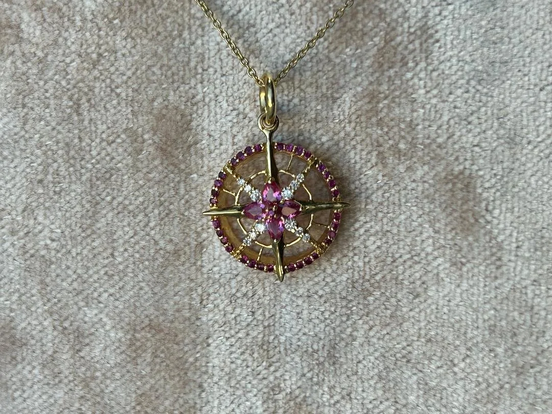 ruby and diamond compass necklace with velvet background