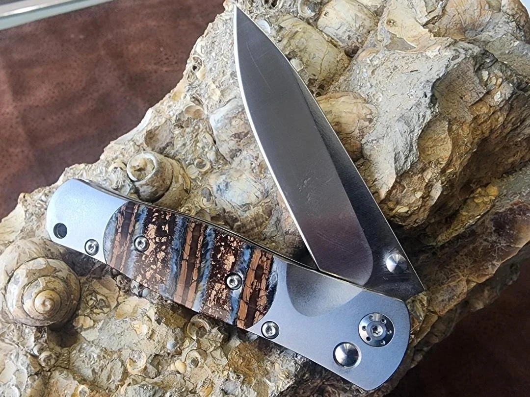 open One knife with mammoth tooth handle on rock