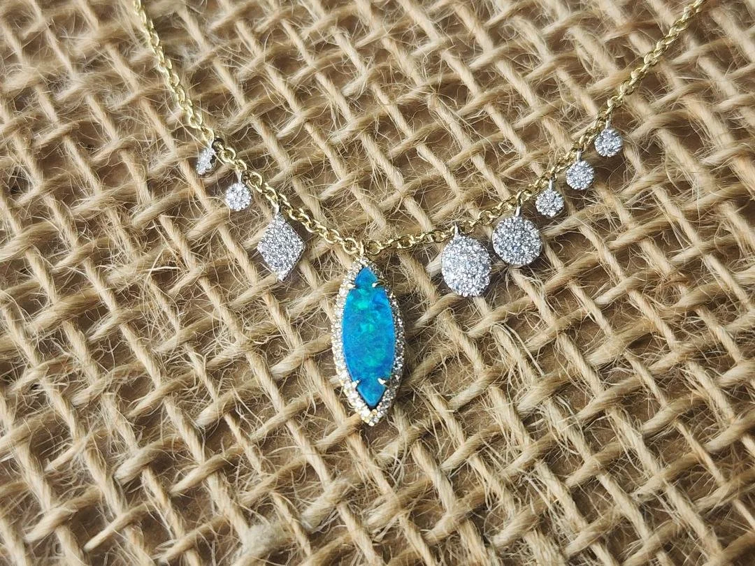Blue green boulder opal necklace with diamond accents on a burlap background