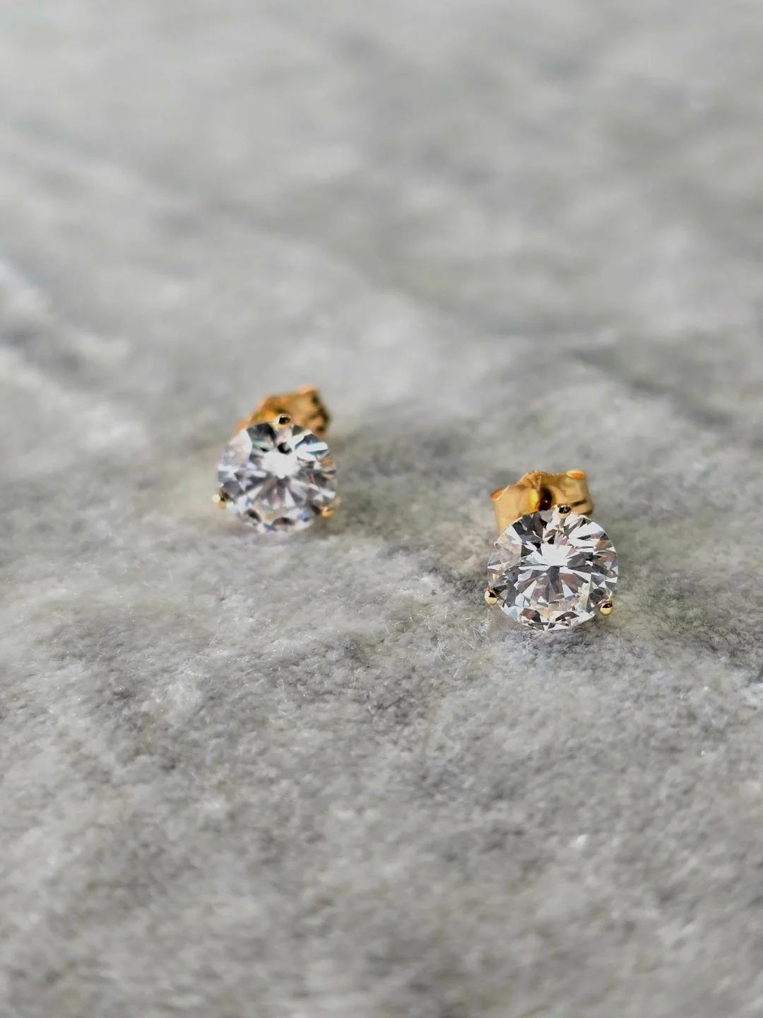 Front view of lab grown diamond studs set on a grey velvet background