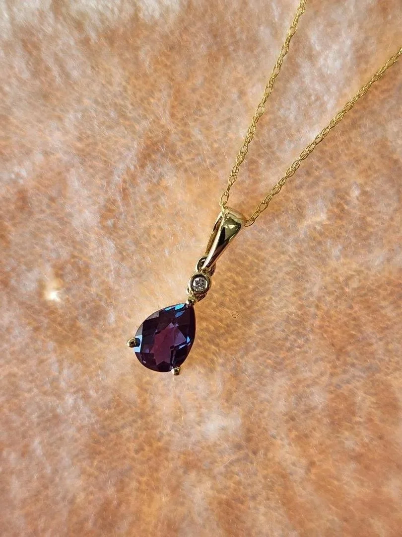 created alexandrite necklace with diamond accent on pink velvet