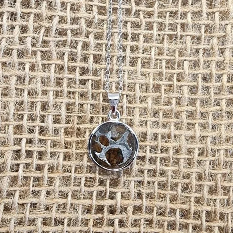 round sterling silver necklace meteorite with a burlap background