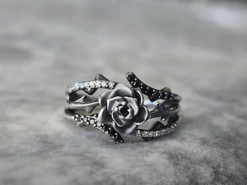 estate sterling silver rose ring with white and black diamonds on grey fabric