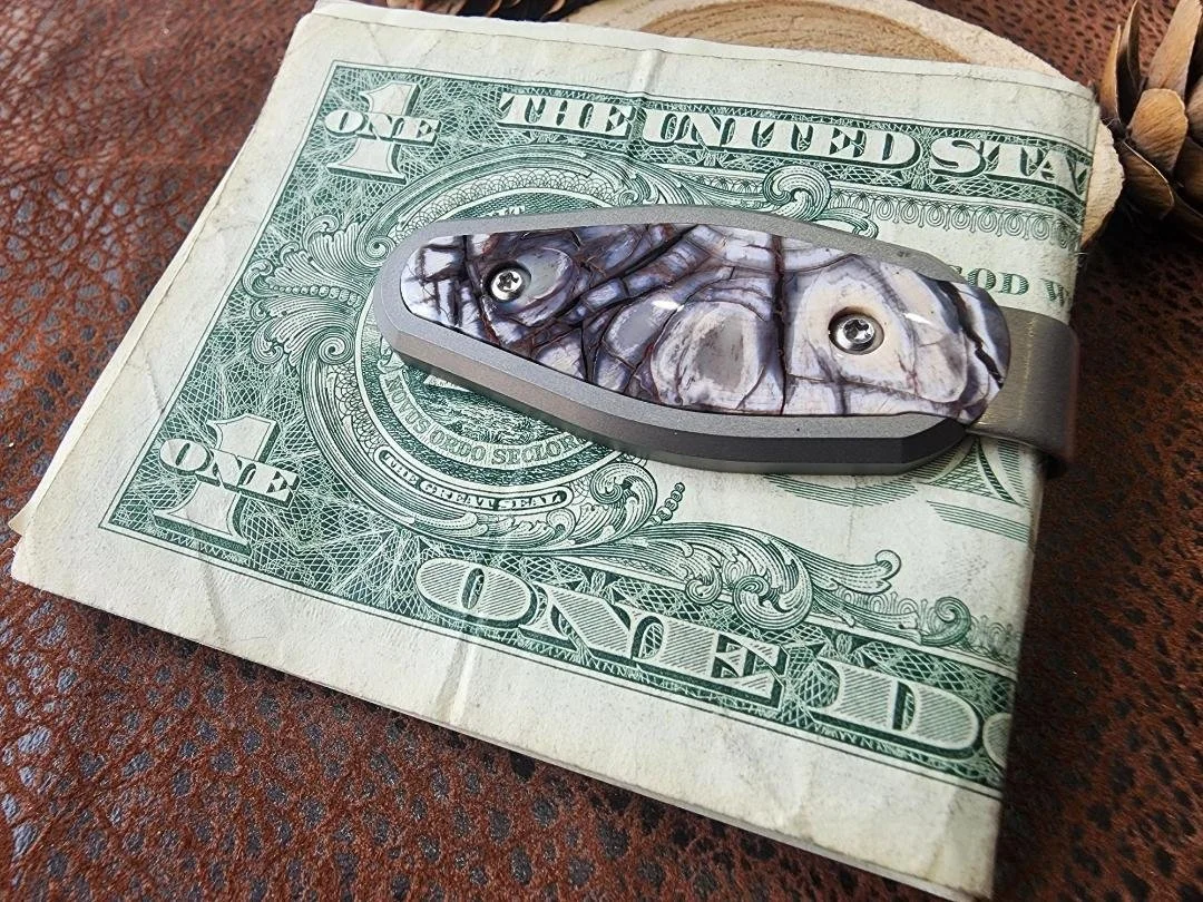 Titanium money clip with dollar bills inlayed with mammoth ivory on wood slice