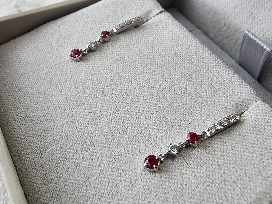 white gold ruby and diamond dangle earrings in grey box