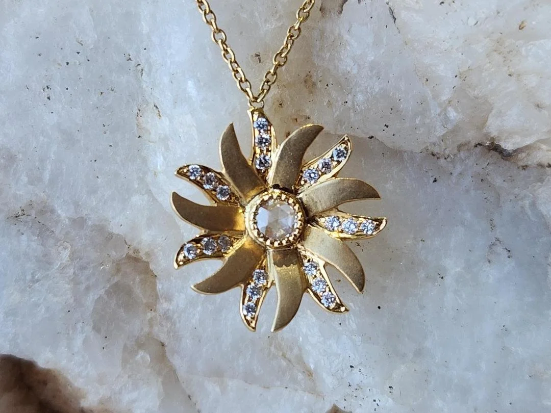 yellow gold diamond flower necklace on white quarts rock