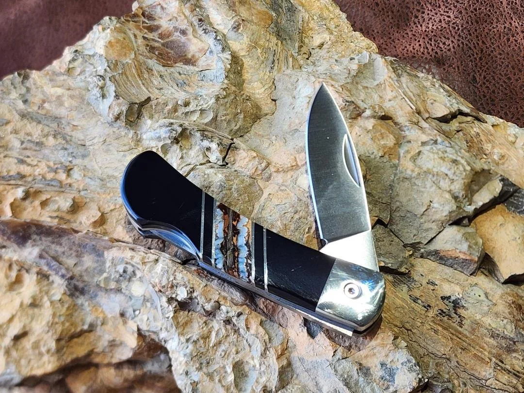 open 3" knife with mammoth tooth inlay and onyx on rock