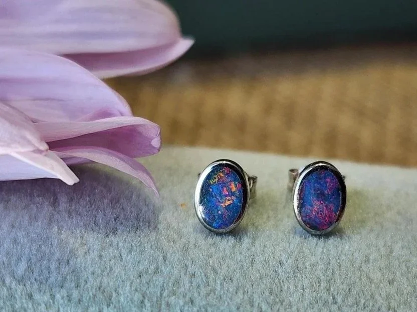 pair of sterling silver boulder stud earrings on blue green box with flower and burlap in background