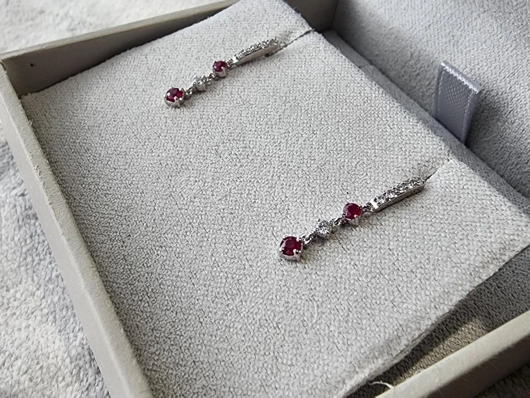 White gold ruby and diamond dangle earrings. In grey box.