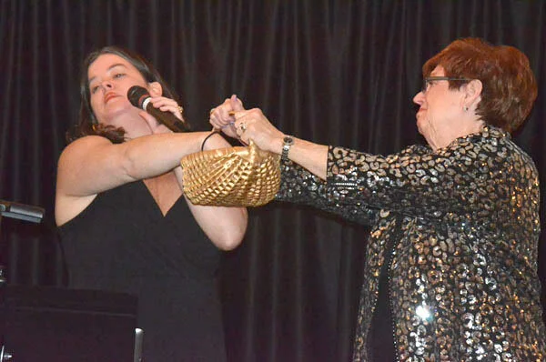 Liz Daley, Golden Gala MC, draws winning raffle ticket from basket held by BJ Costs