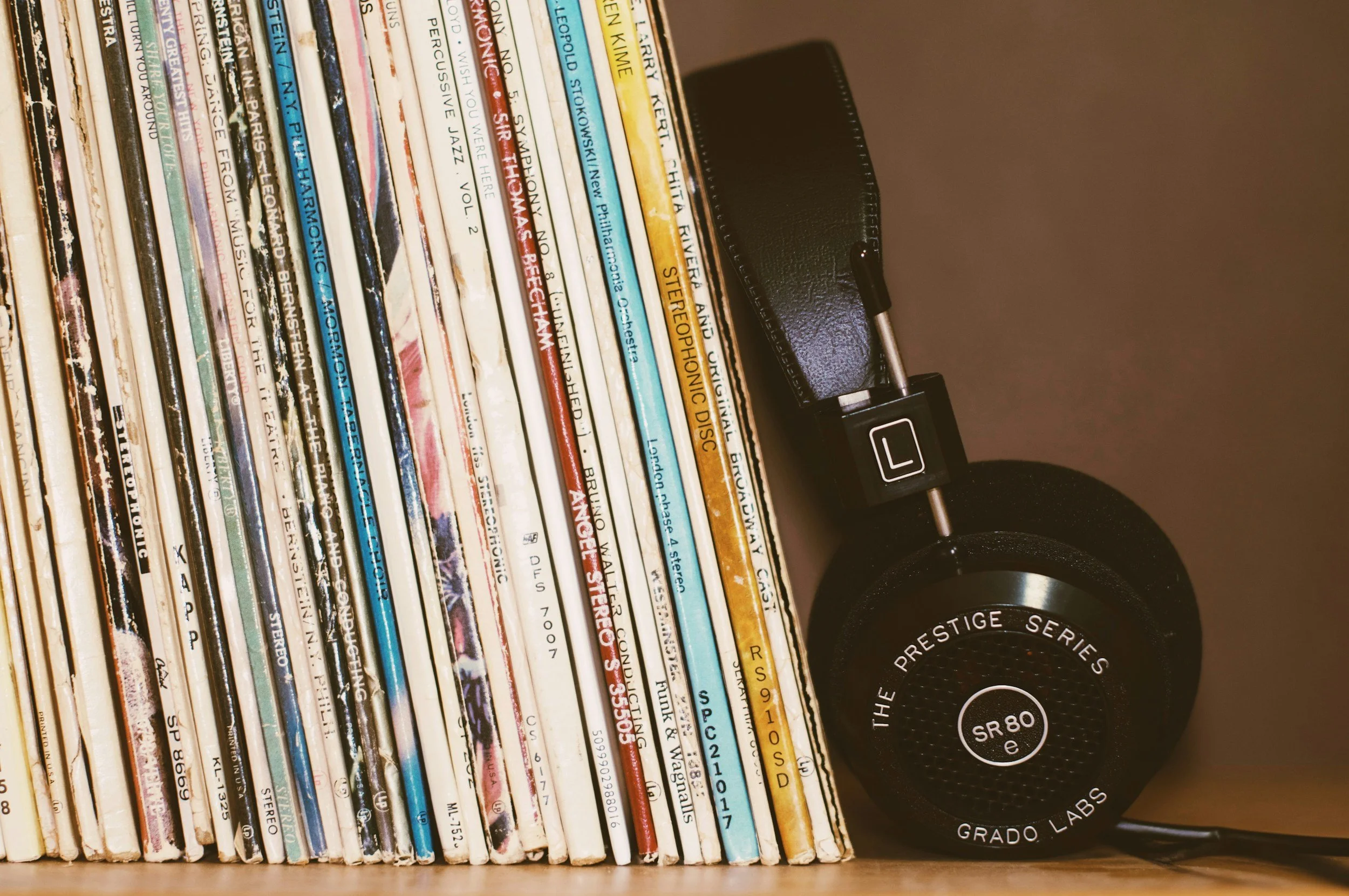 records and headphones on a wood shelf