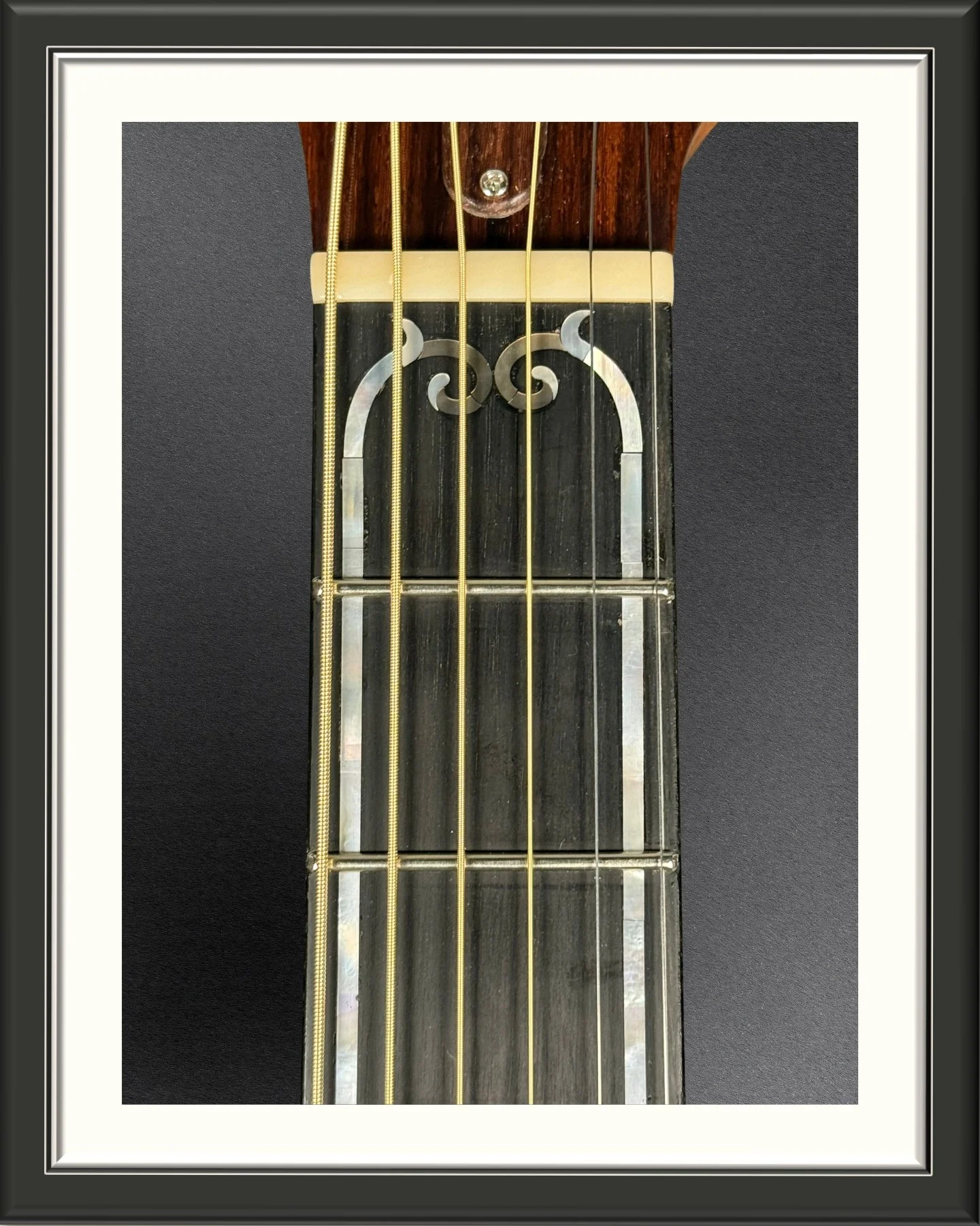 Close up of the custom inlay in the fretboard of the ECA acoustic guitar that was inspired by art nouveau stained glass in transom windows