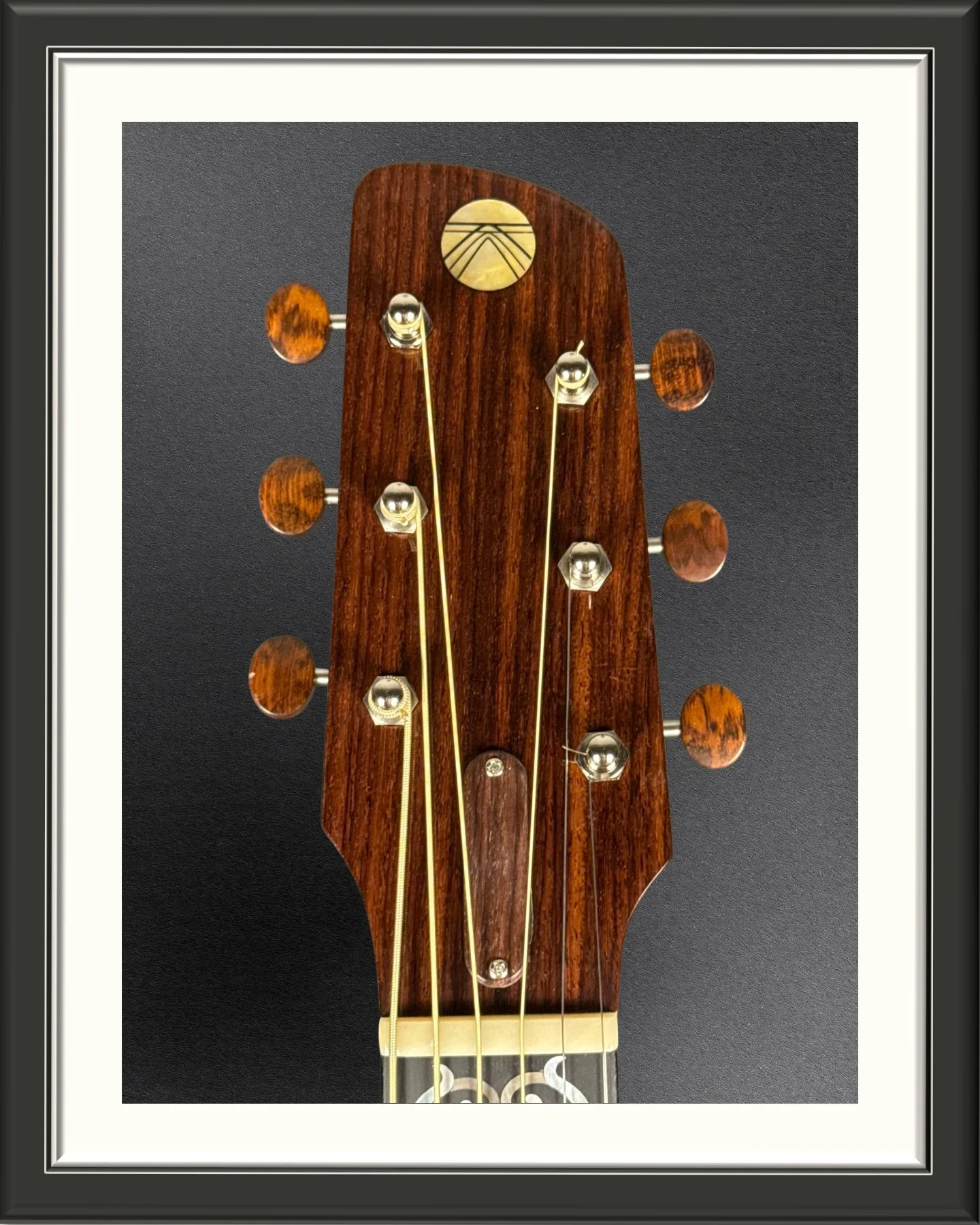 Close up of the front of the headstock of the ECA custom acoustic guitar in Indian Rosewood