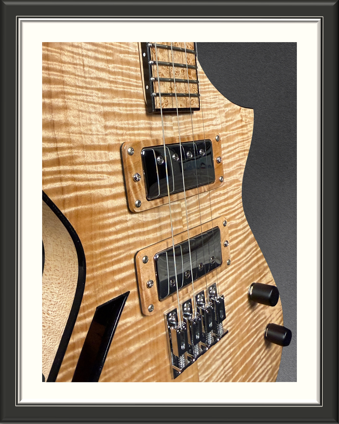 Close-up, angled photo of the body of the MachMachines Cuyler Model all-maple, hollow-body, electric baritone ukulele