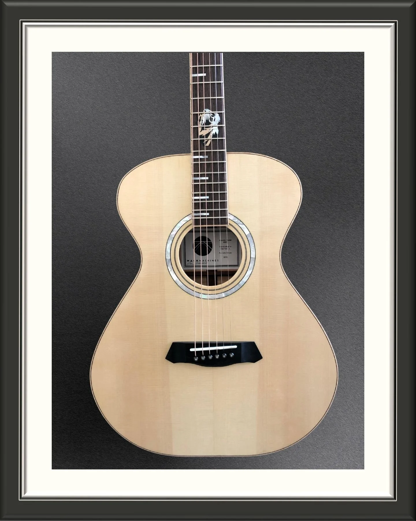 Acoustic guitar with Mother of Pearl inlay.