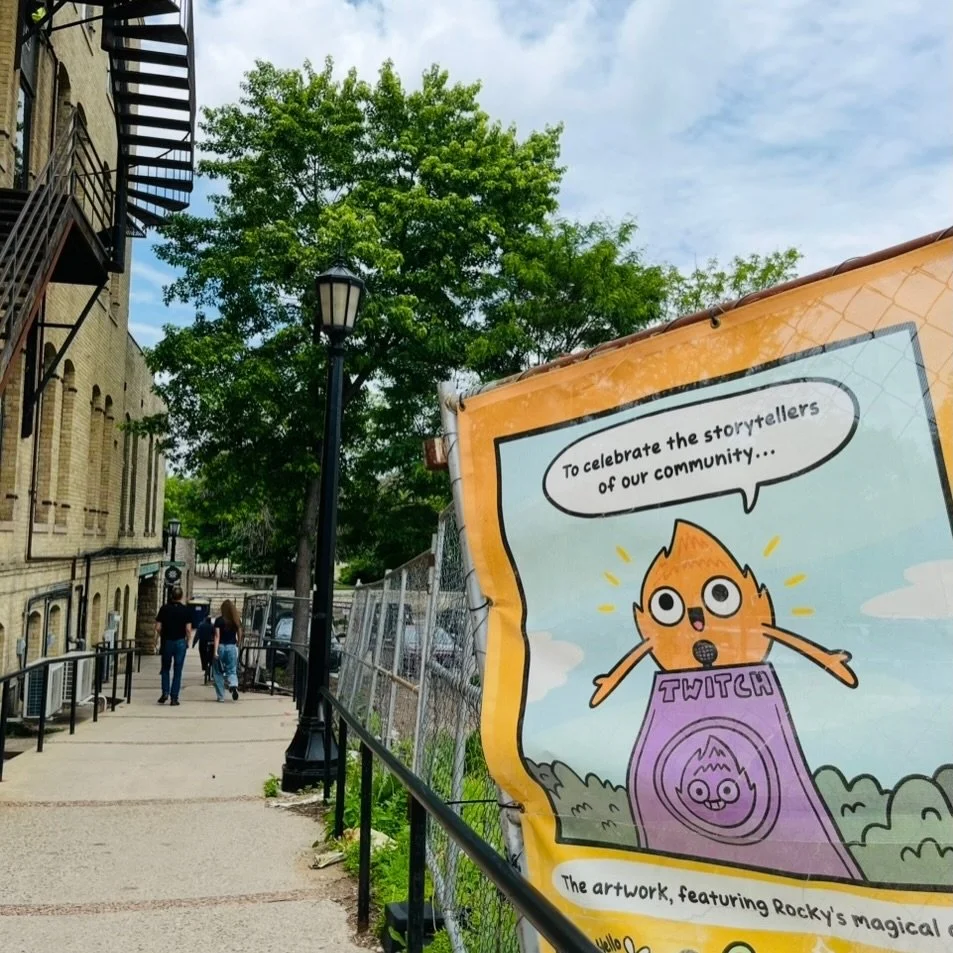 Twitch says hello from downtown Northfield! This winter, I was commissioned by the City to design a massive 170 foot mural to celebrate the storytellers of our community!

Over 100 books by Northfield authors are featured in the artwork! I was honore