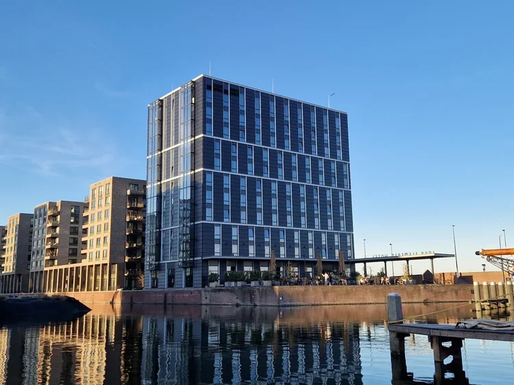 Green hotel architecture incorporating natural ventilation, passive cooling, and daylight optimization reduces HVAC demand, lowers energy consumption, and enhances guest comfort through sustainable building design principles.