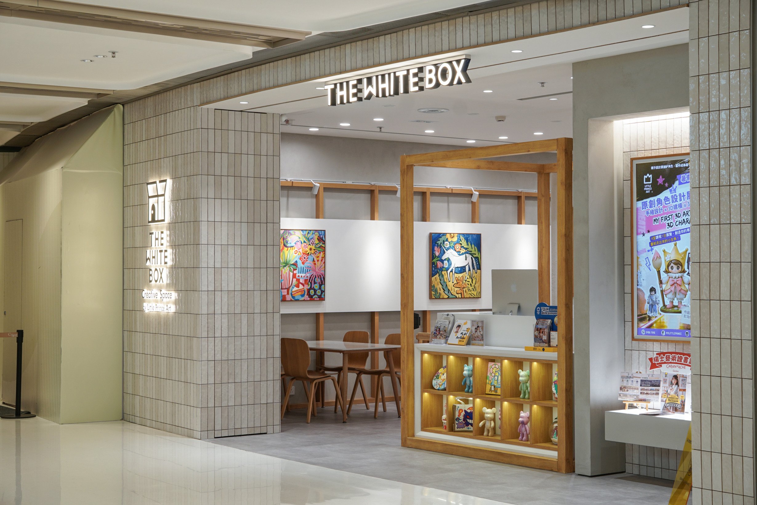 Children's art studio entrance with white handcrafted ceramic tiles and wooden framing.