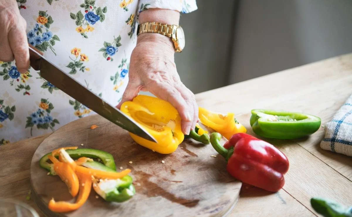An older woman cooking at home after regaining mobility through acupuncture and herbal medicine