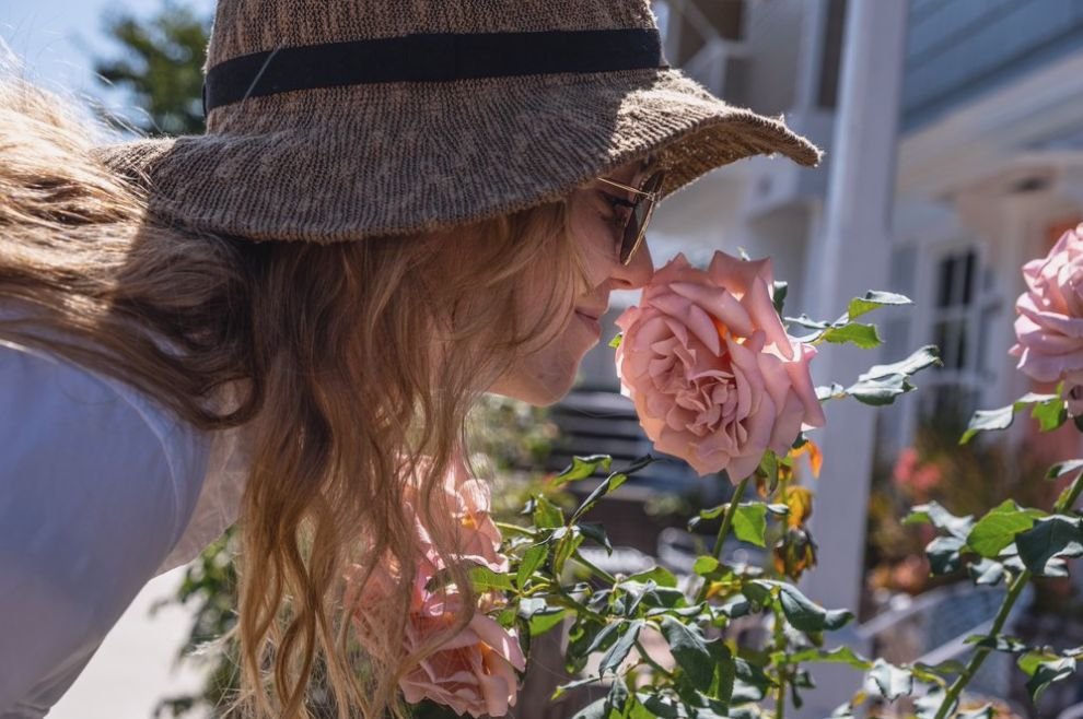 Woman smelling roses after recovering taste and smell during long-haul COVID