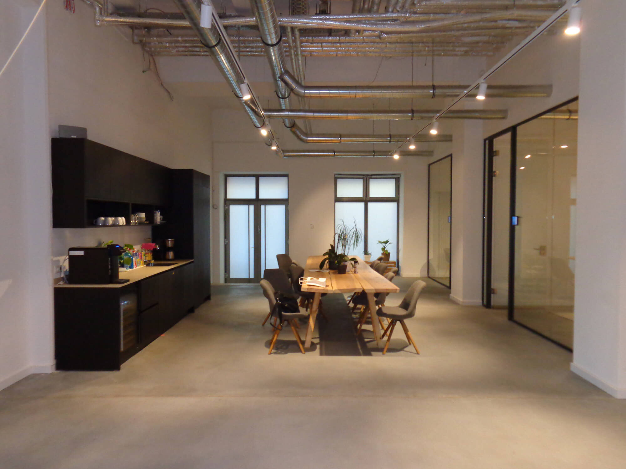 Friedenstr. 91A Berlin - Küche mit anthrazitfarbener Laminatstruktur und Stahltüren für den gewerblichen Gebrauch. Pantry und Drewers in schwarz matt lackiertem Eichenfurnier mit offenen Regalen aus Eisen und Glas.