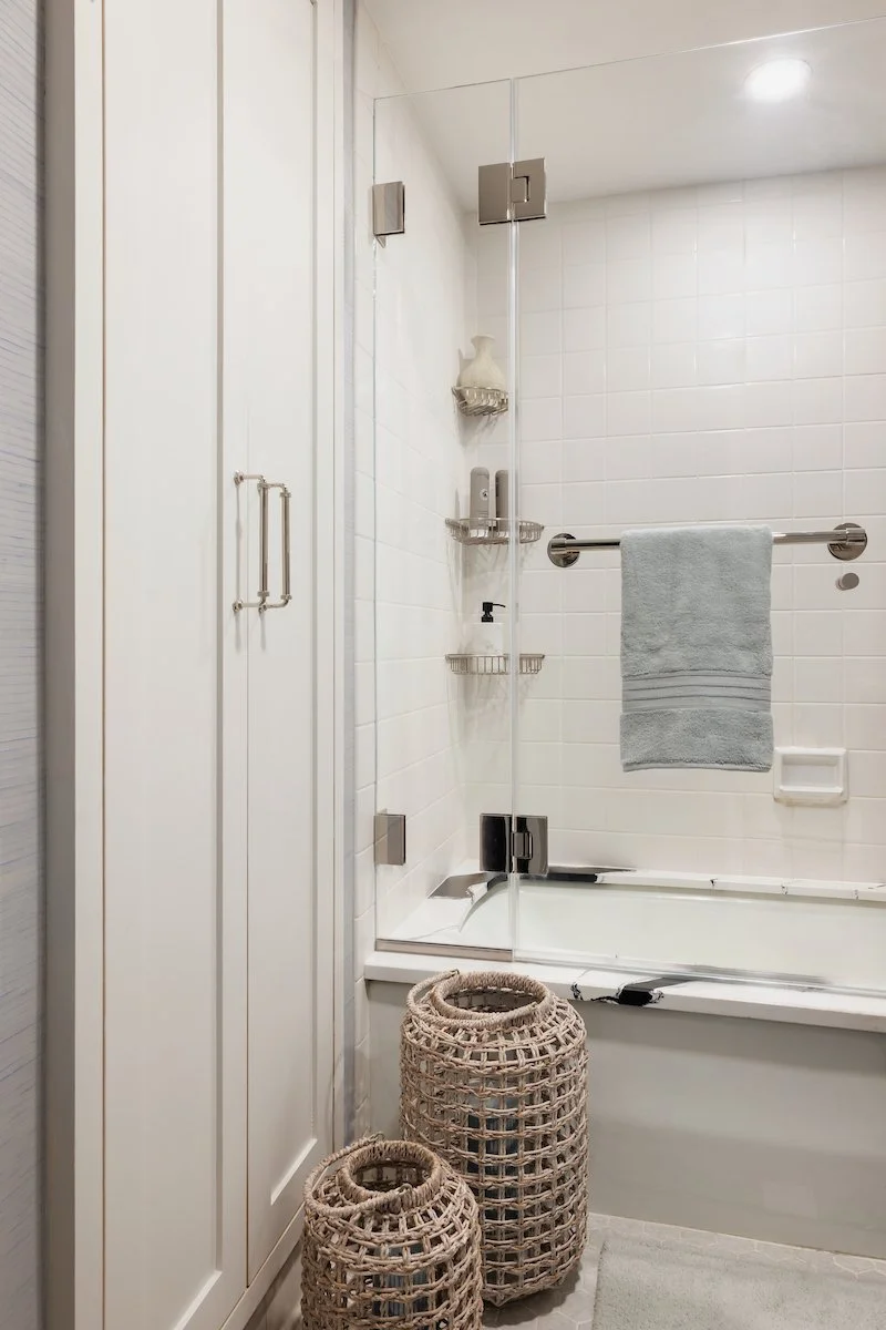 Elegant glass shower enclosure with polished hardware and white tile in a thoughtfully designed NYC bathroom.