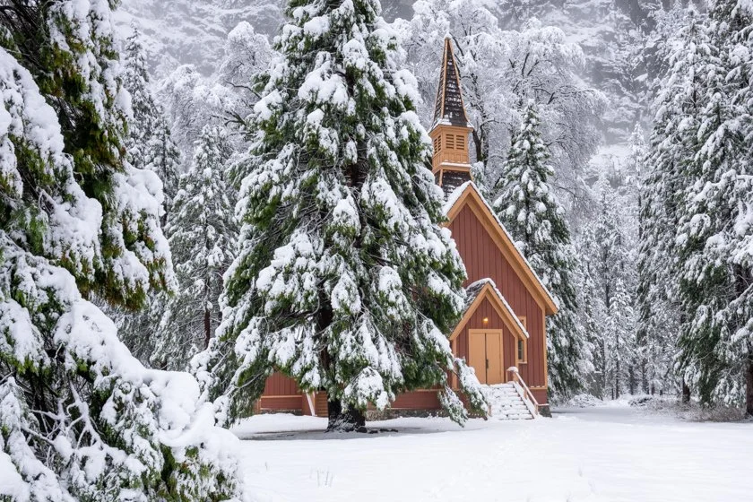 chapel in Yosemite National Park surrounded by pine trees in snow