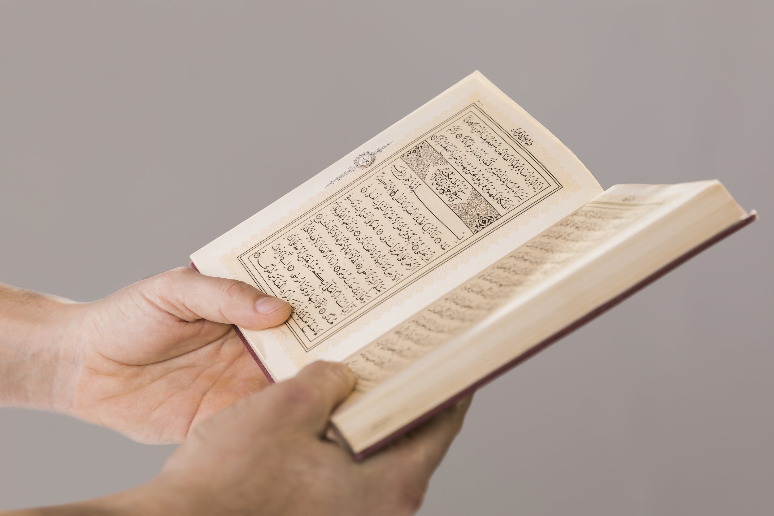 quran-being-held-hands-close-up.jpg