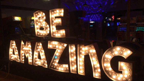 A flashing incandescent sign reading "Be Amazing".
