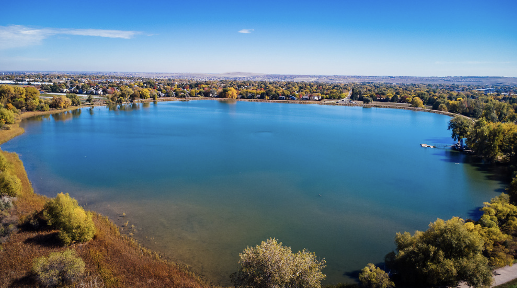 Drone shot of pond in Lafayette Colorado from above. Surrounded by trees