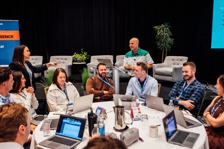 A small group smile and work together during a breakout session at the national corporate housing conference