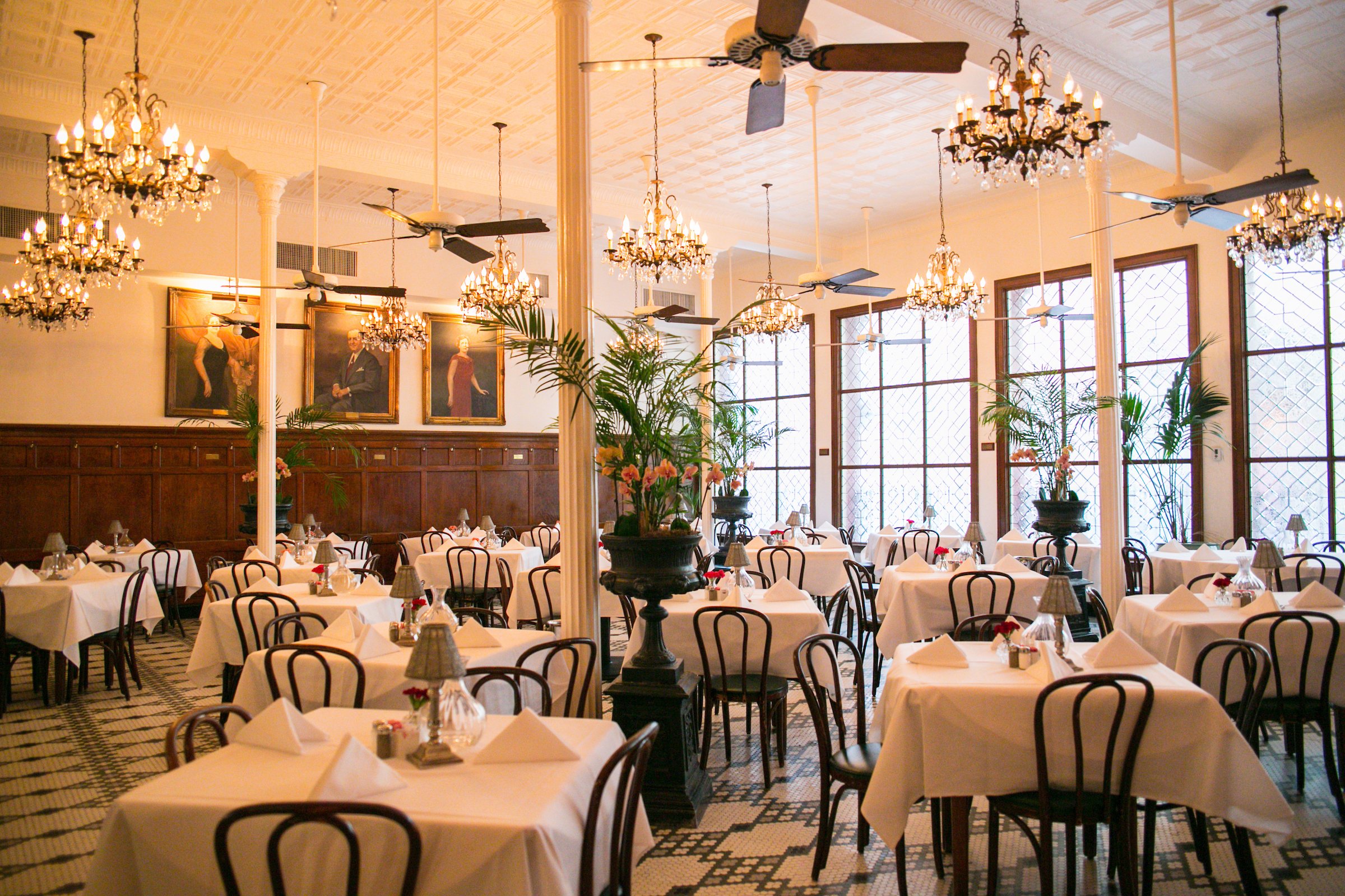New Orleans restaurant. White table cloths and chairs and chandeliers