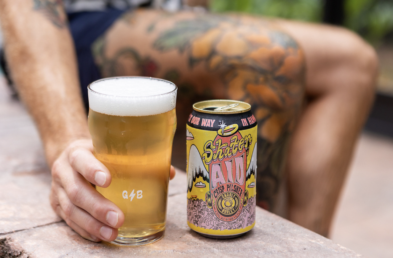 A beer can sitting next to a full glass