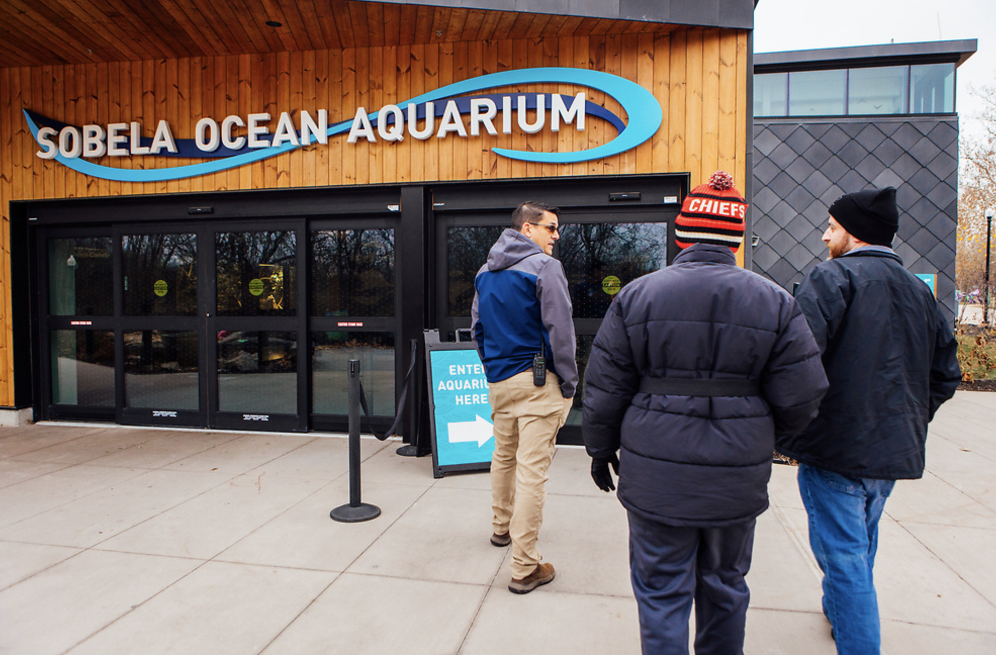 Three men walk into the Sobela Ocean Aquarium