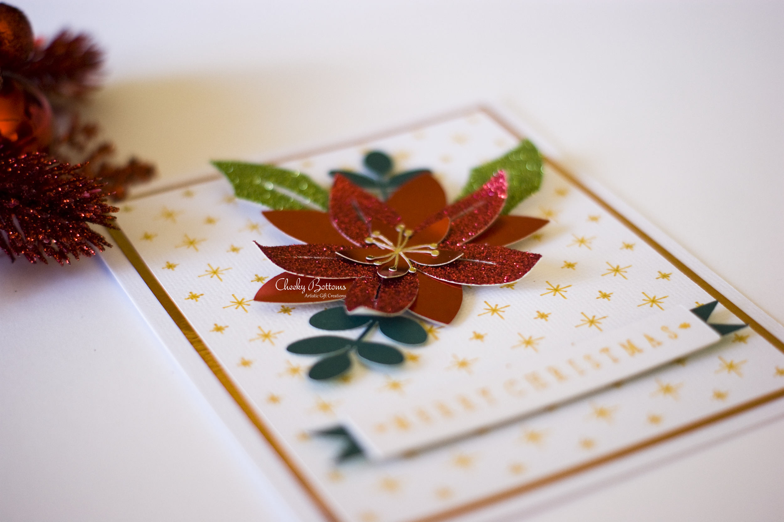 Merry Christmas greeting card featuring a beautiful poinsettia made with glitter and foil cardstock.