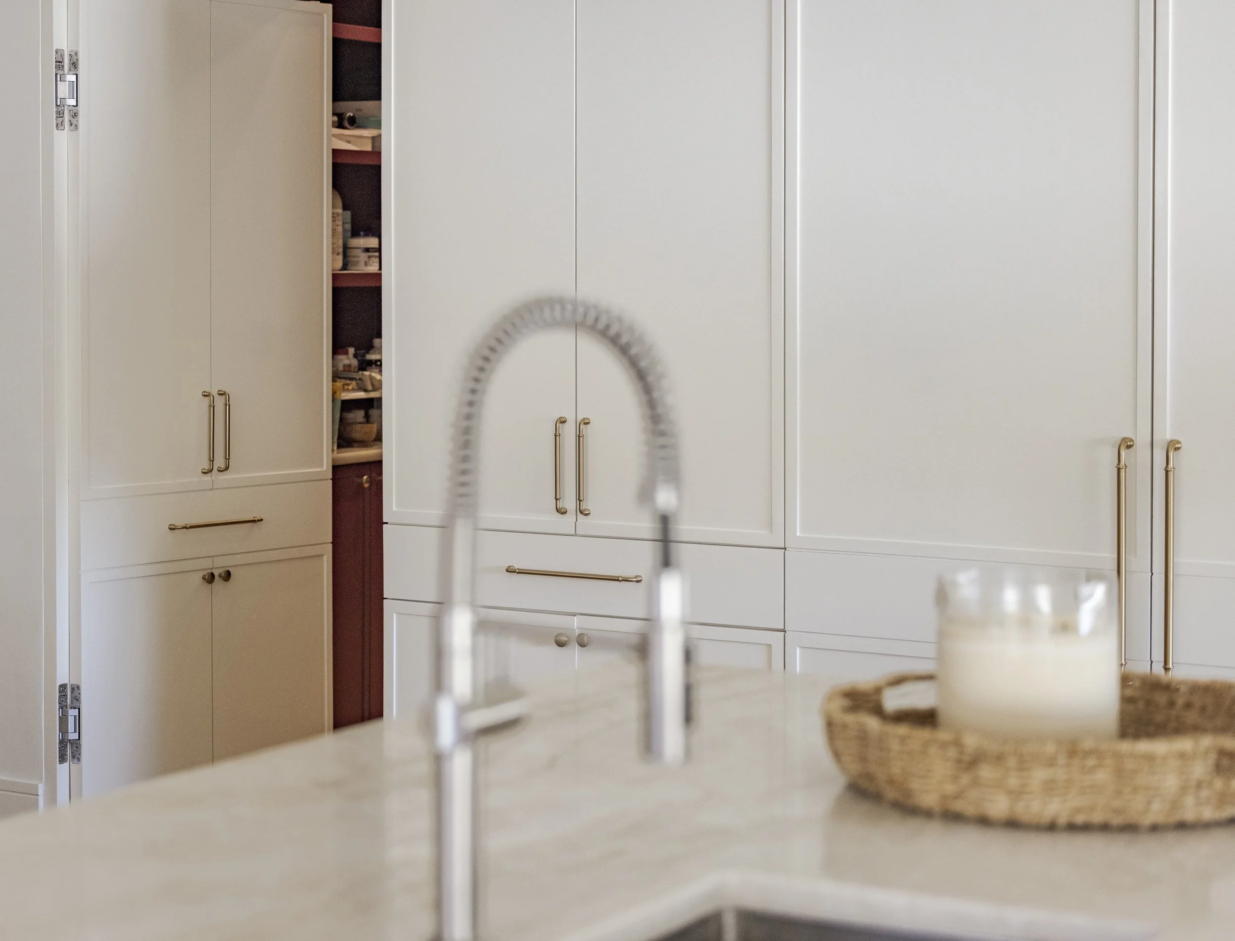 Peek of hidden pantry behind custom cabinet door