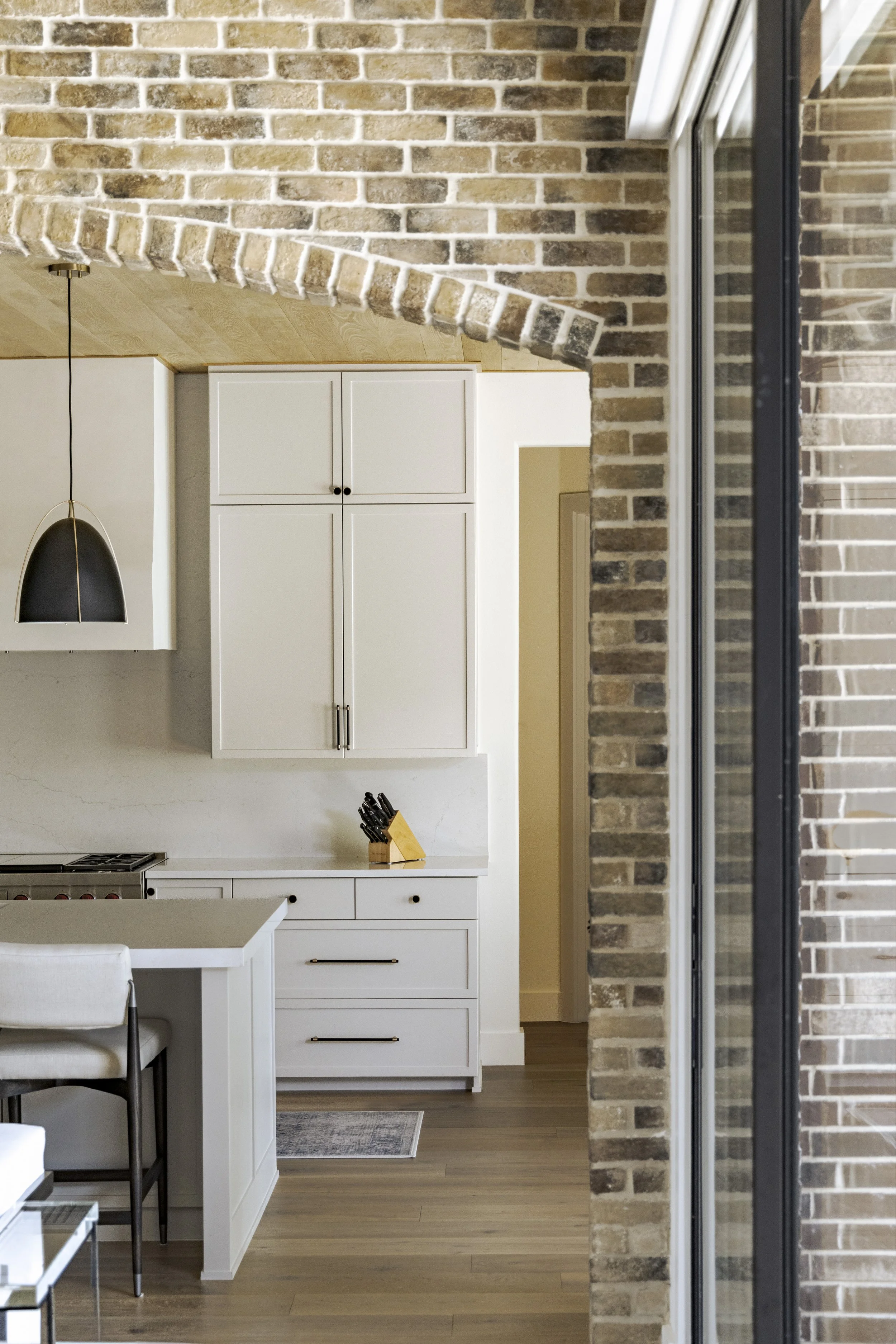 LIghter Family Room to Kitchen-Counter-Stools-Pendant-Cabinets Brick Arch & Beams.jpg