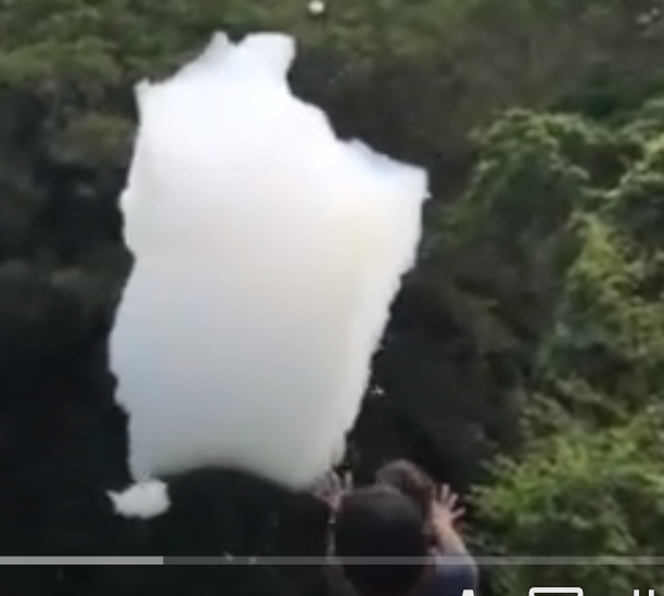 Okinawan children play with giant toxic “snowflakes” near the U.S. Marine Corps Air Station Futenma, Okinawa. [Photo courtesy of YouTube]