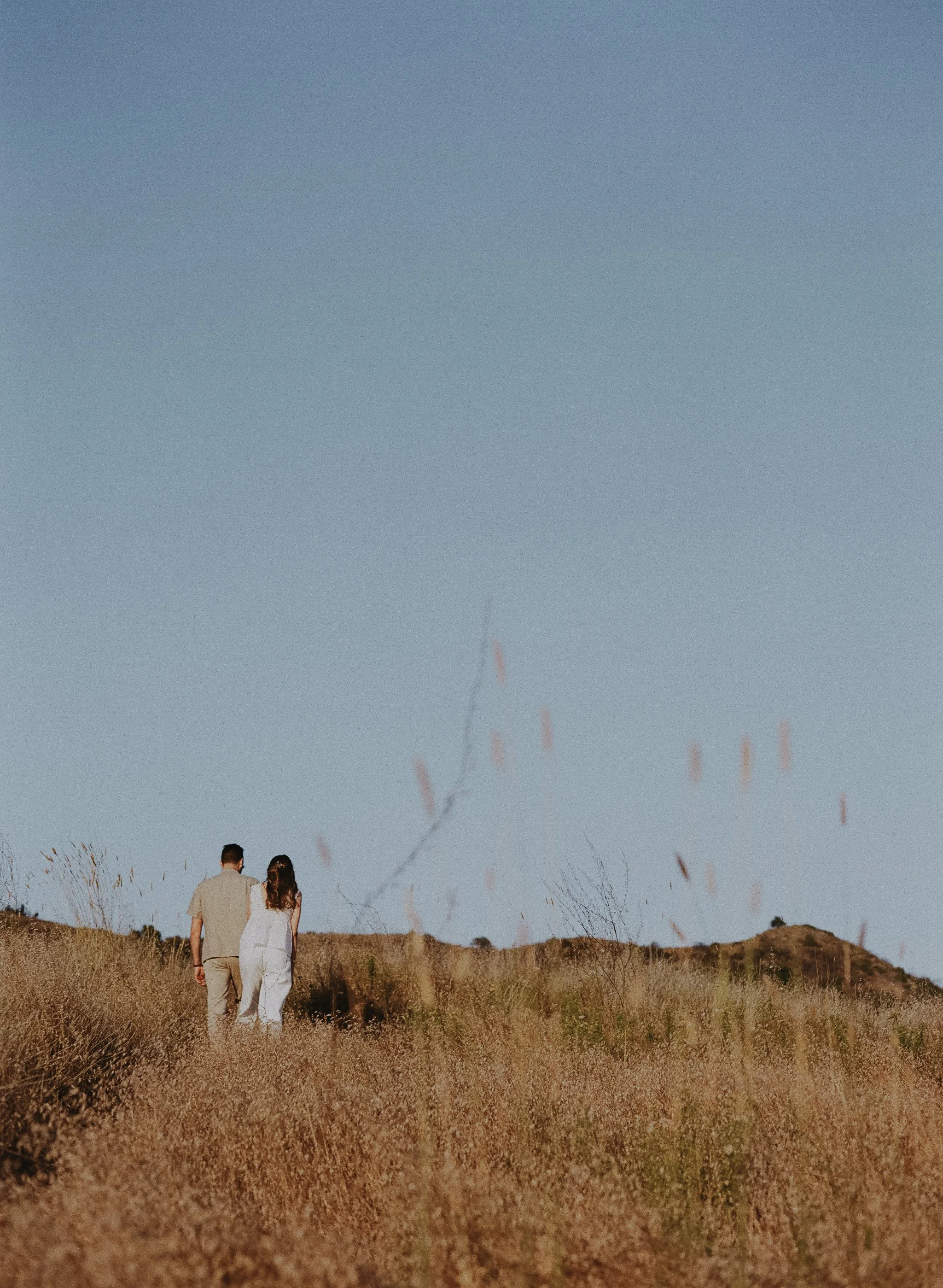 Relationship therapist Rachel Neporent and her husband walking through dunes in California