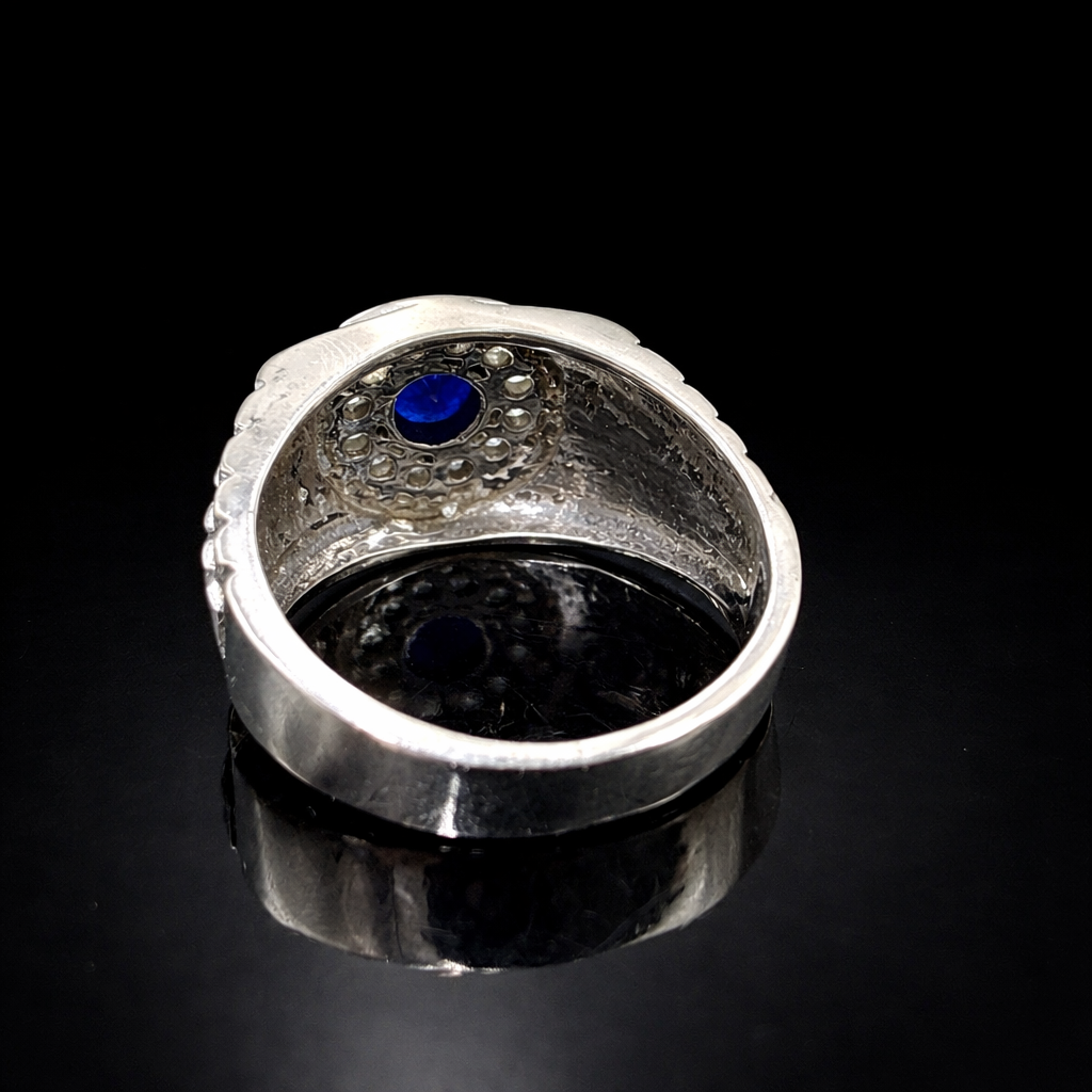 Blue sapphire in silver ring close-up.png