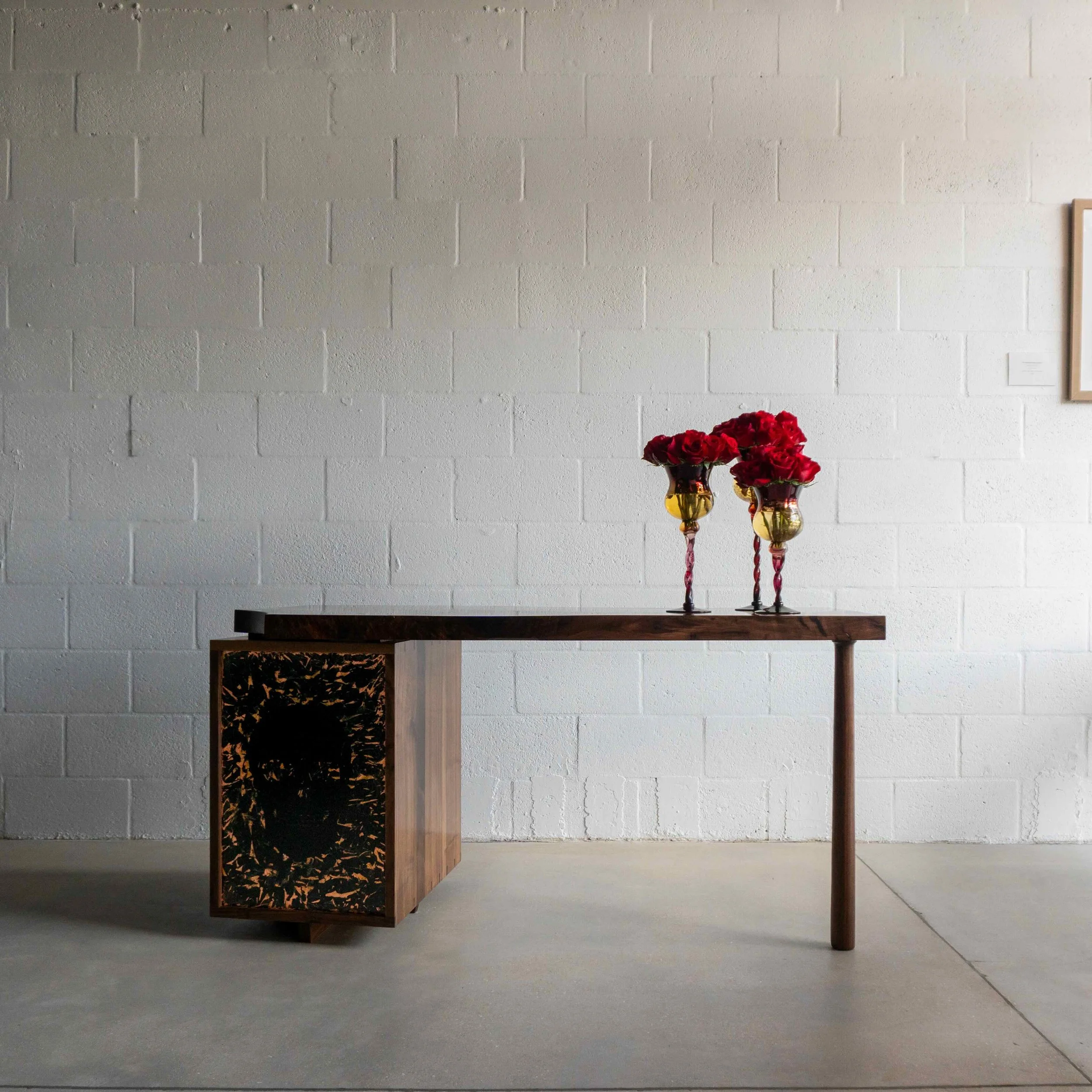 Aurelius Desk with skull patination with red roses in the front of the studio.