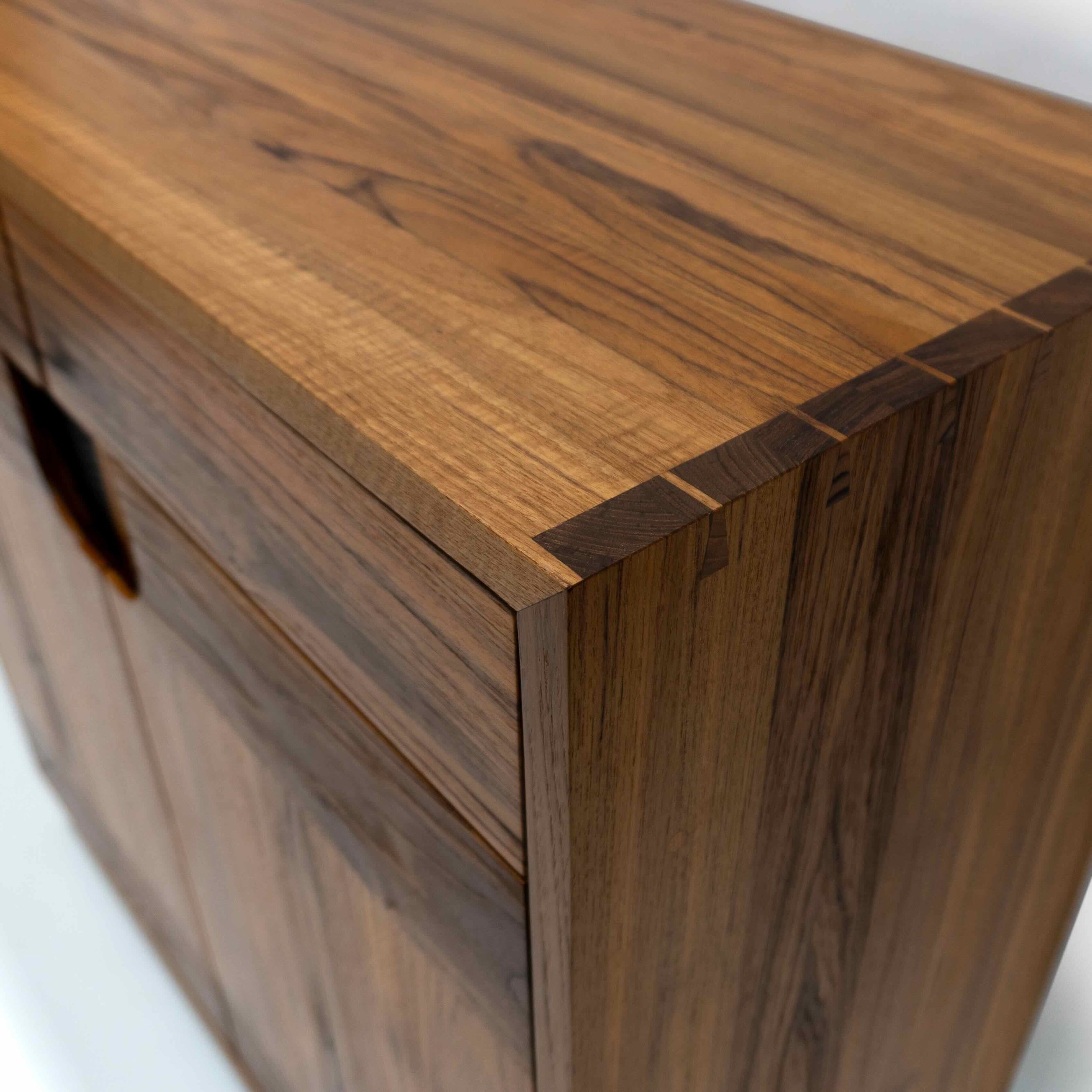 Mitered dovetails on Arexion High Credenza, in teak with python leather.